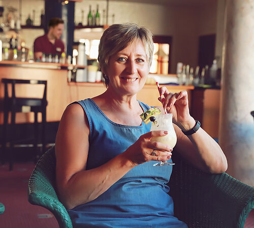 Frau mit Cocktail an der Bar